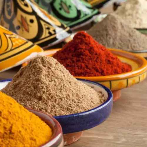 Diversity of Moroccan powder herbs in colorful ceramic tagines close up